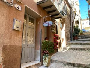 a building with a door and stairs in a street at La locanda Lulù in Castelbuono