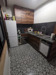 a kitchen with a white refrigerator and a tile floor at Homey art apartment next to Drujba lake Metro stations and bul.Tsarigradsko Shose in Sofia