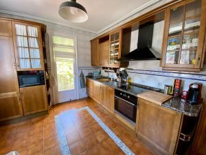 a kitchen with wooden cabinets and black counter tops at Apartamento Rural El Balcón in Alhama de Aragón