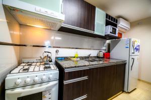a kitchen with a white stove and a refrigerator at Estrella de Mar in Villa Carlos Paz +14 photos