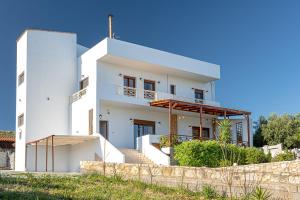 una casa blanca con una valla delante en Thalasinos Luxury Villa, en Gournes