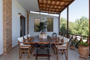 una mesa de madera y sillas en un patio en Thalasinos Luxury Villa, en Gournes