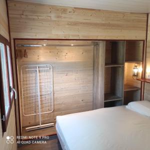 Velleronにあるle Mas de la Jardineの木製の壁のベッドルーム1室(ベッド1台付)