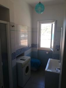a bathroom with a washing machine and a window at CASA Verde BELLAVISTA in Nicotera