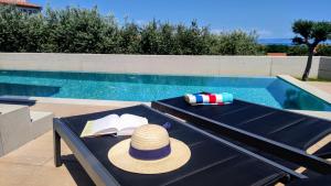 een hoed op een tafel naast een zwembad bij Villa Leola in Ližnjan