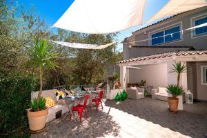 a patio with a table and chairs and an umbrella at Maison27 in Budoni
