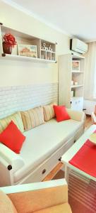a white couch with red pillows in a living room at Дом Анести in Varna City