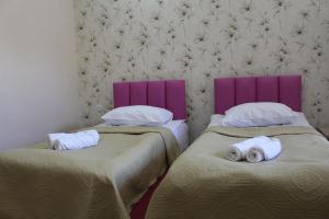 two beds in a room with purple headboards at Hotel Rabati in Akhaltsikhe