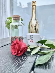 a rose and a bottle and a cup on a table at Romantic room for two persons in Poreč +20 photos