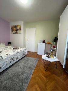 a bedroom with a bed and a table and a refrigerator at Romantic room for two persons in Poreč