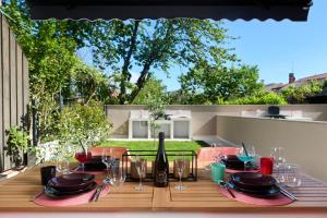 drewniany stół z butelką wina i kieliszkami w obiekcie Apartments Dolcea w mieście Umag