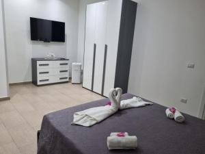 1 dormitorio con 1 cama con toallas y TV en Appartamenti a Gallipoli, en Gallipoli