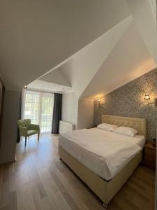 een slaapkamer met een groot wit bed en een stoel bij Akpinar Hotel in Uzungol +102 foto's