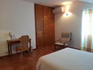 a bedroom with a bed and a desk and chair at Domaine de Valle in Sorbo-Ocagnano