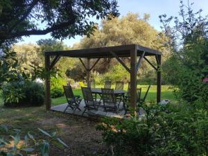 a wooden gazebo with chairs and a table at Domaine de Valle in Sorbo-Ocagnano