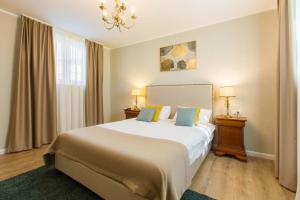 a bedroom with a large bed with two night stands and two lamps at Pool House Mamaia in Mamaia Nord