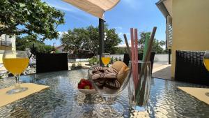 a table with a bowl of fruit and glasses of wine at House Roca in Vodice