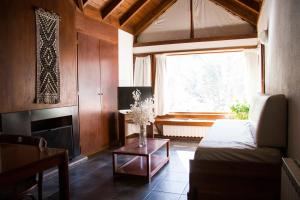 ein Wohnzimmer mit einem Sofa und einem Fenster in der Unterkunft Rincón de los Andes Resort in San Martín de los Andes