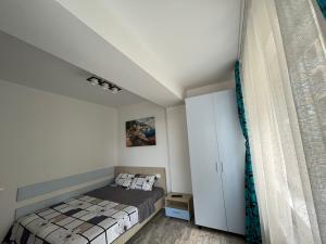 ein Schlafzimmer mit einem Bett und einem weißen Schrank in der Unterkunft Apartament Giulia Mamaia Nord in Mamaia Nord – Năvodari