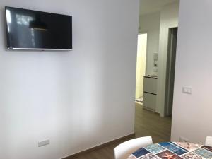 a living room with a table and a television on a wall at Chioggia House di Marco in Chioggia