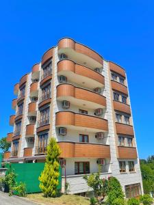 a tall apartment building with balconies on it at LUSTRA GARDEN SUİTE in Trabzon