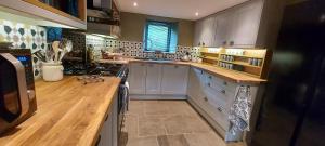 eine Küche mit grauen Schränken und einer hölzernen Arbeitsplatte in der Unterkunft Luxurious 4 bedroom Cottage in the Yorkshire Dales in Richmond + 34 Fotos