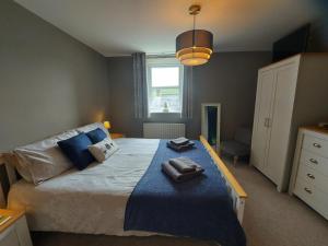 a bedroom with a large bed with a blue blanket at Luxurious 4 bedroom Cottage in the Yorkshire Dales in Richmond