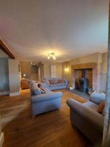 ein Wohnzimmer mit zwei Sofas und einem Kamin in der Unterkunft Luxurious 4 bedroom Cottage in the Yorkshire Dales in Richmond