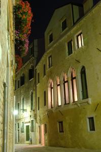 un vieux bâtiment dans une ruelle la nuit dans l'établissement Hotel Cà Zusto Venezia, à Venise
