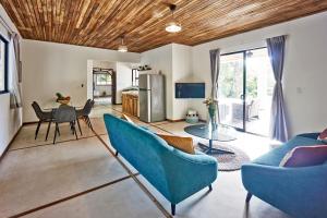 a living room with blue chairs and a table at Villa Ananda in Mal País