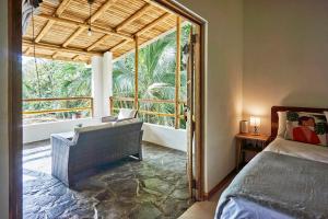 a bedroom with a bed and a large window at Villa Ananda in Mal País +30 photos