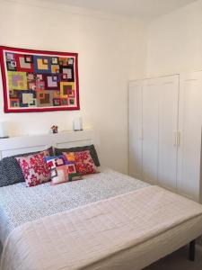 a bedroom with a bed with pillows and a painting at La Nina in Sangano