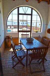 een tafel en stoelen in een kamer met een groot raam bij La Esperanza in Medina Sidonia