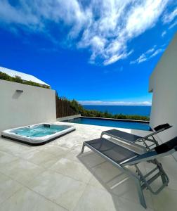a patio with a chair and a swimming pool at Sul Villas & Spa - Azores in Lagoa