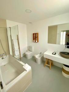 baño con 2 lavabos, bañera y 2 aseos en Sul Villas & Spa - Azores en Lagoa