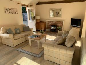 a living room with two couches and a table at Bramble cottage at Waingrove Farm in Louth