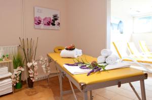 Zimmer mit gelbem Tisch und Handtüchern darauf in der Unterkunft Hotel Hof Sudermühlen in Egestorf