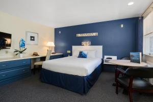 ein Schlafzimmer mit einem großen Bett und einer blauen Wand in der Unterkunft The Even'tide in Wellfleet