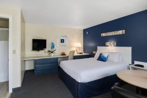 a hotel room with a large bed and a table at The Even'tide in Wellfleet