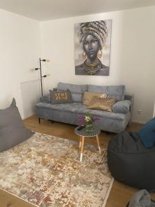 a living room with a blue couch and a statue at Adria Villa Apartment family and friends in Velden am Wörthersee