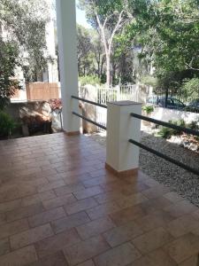 un portico con un tavolo bianco su un patio di Gli ulivi -Appartamento al centro a Cala Gonone