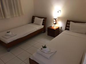 a room with two beds and a table with a lamp at Town House, Ilios II, Kato Paphos in Paphos City