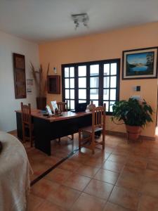a living room with a desk and a table and chairs at Hostal Tierra del Sol in Salta