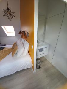 een slaapkamer met een wit bed en een spiegel bij Chambre d'hôtel tout confort au Pays des Abers in Plouguerneau