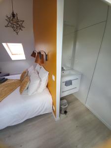 a bedroom with a white bed and a mirror at Chambre d'hôtel tout confort au Pays des Abers in Plouguerneau