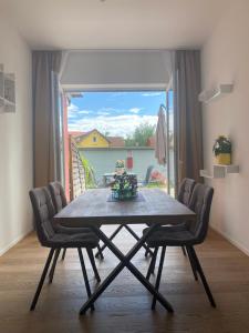 a dining room table with chairs and a large window at Adria Villa Apartment family and friends in Velden am Wörthersee