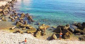 two people on a beach with rocks and the water at La Medusa d'Ortigia in Syracuse +9 photos