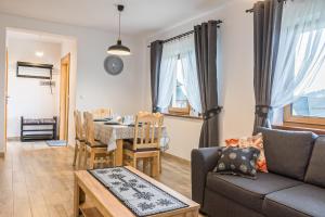 a living room with a table and a dining room at Apartamenty ROZETA Poronin in Poronin