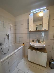 een badkamer met een bad, een wastafel en een douche bij Adria Villa Apartment family and friends in Velden am Wörthersee