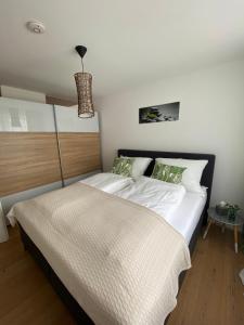 a bedroom with a large bed with white sheets at Adria Villa Apartment family and friends in Velden am Wörthersee
